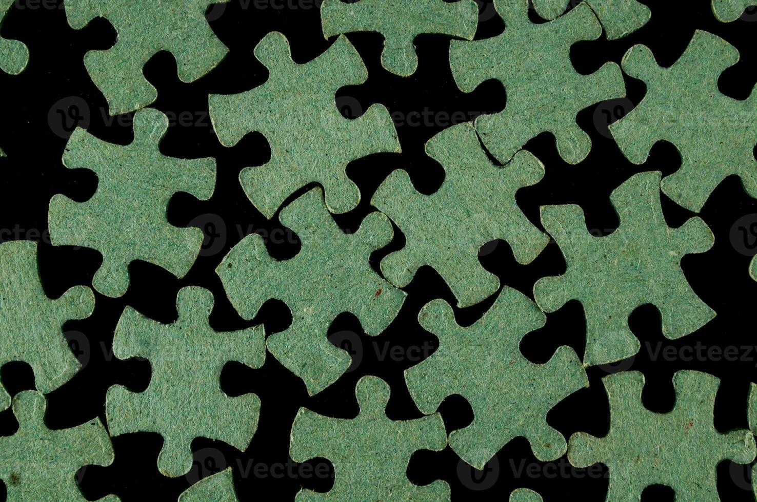 a green puzzle piece is shown on a black background photo