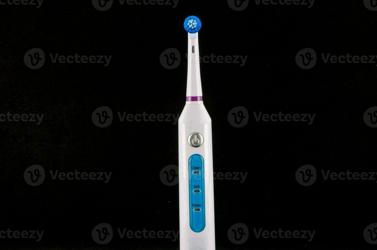 a white and blue electric toothbrush on a black background photo