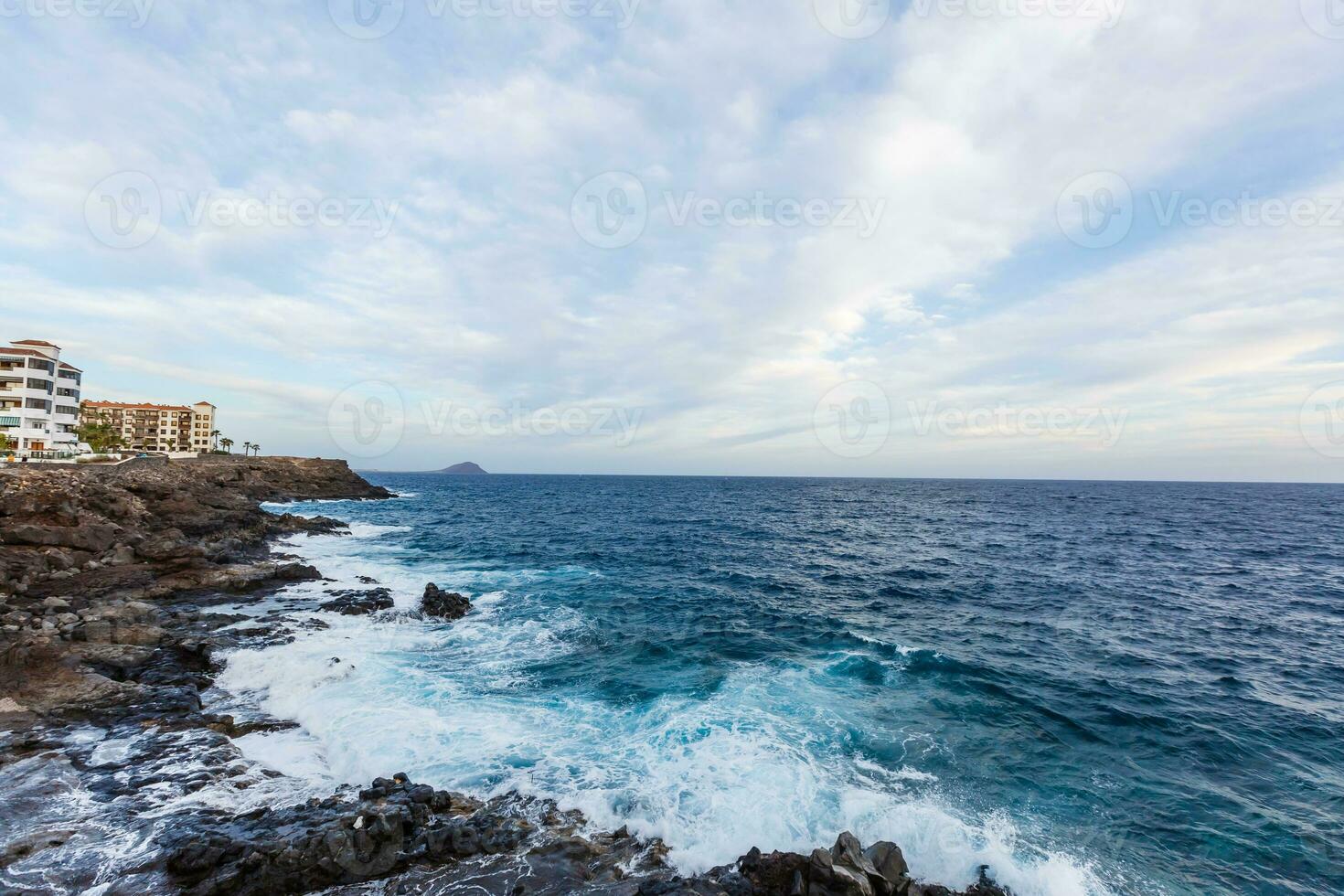 ocean waves hit and crash against stones photo