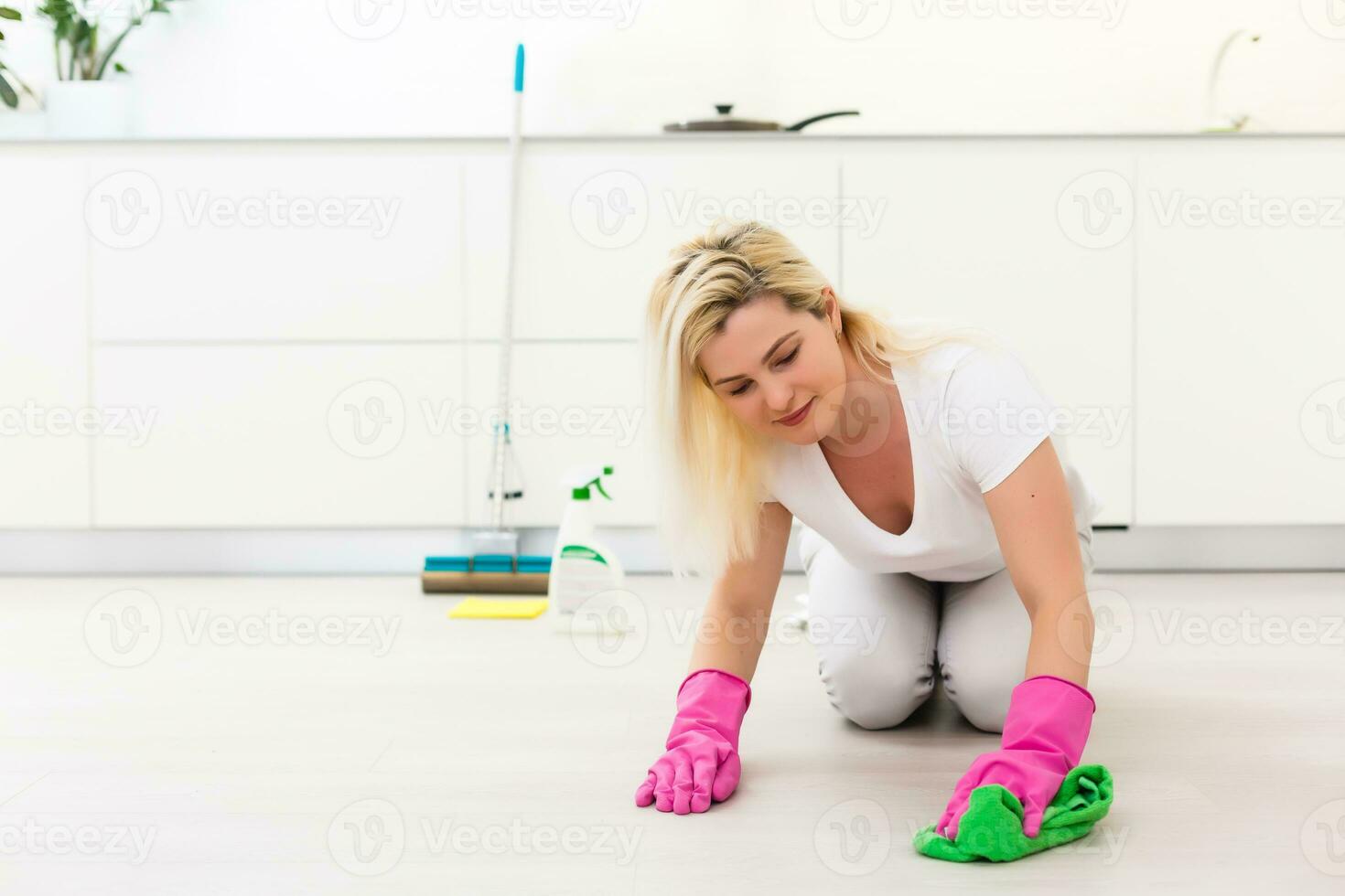 Woman holding mop and bucket with cleaning agents at home photo