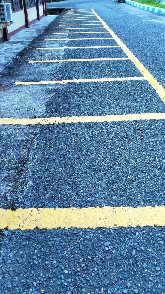 Empty parking space for motorbikes and bicycles with yellow lines. Automobile parking garage at office area parking lot photo