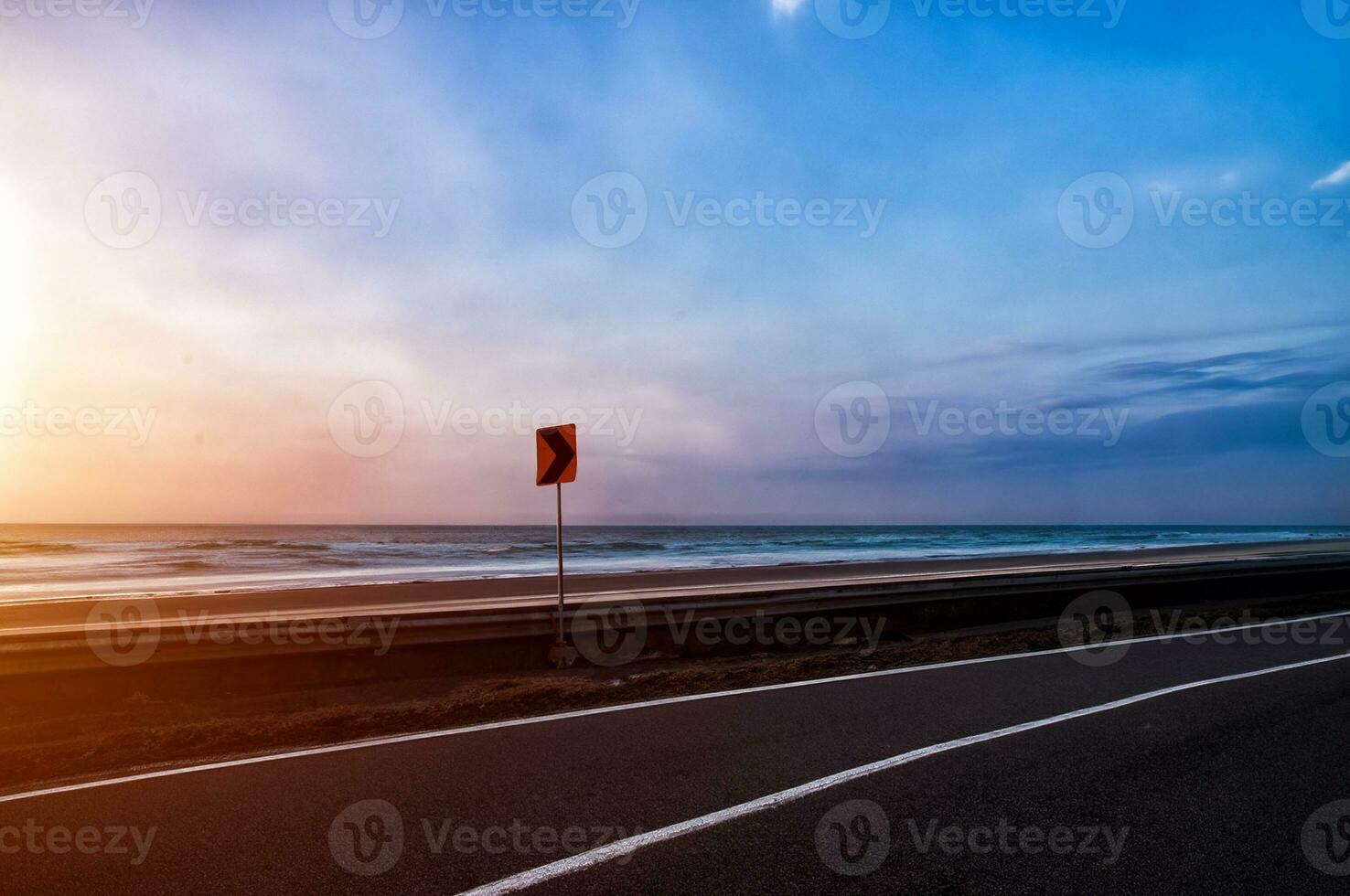 el la carretera vueltas a lo largo el playa a puesta de sol foto