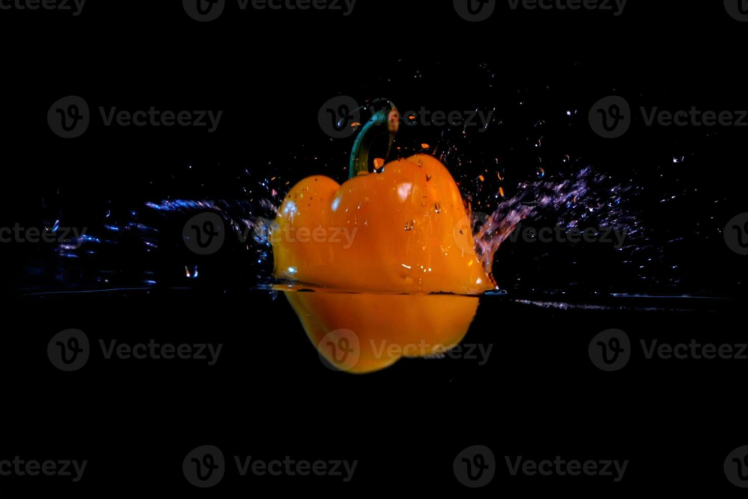 bell peppers are dropped into the water causing a splash photo