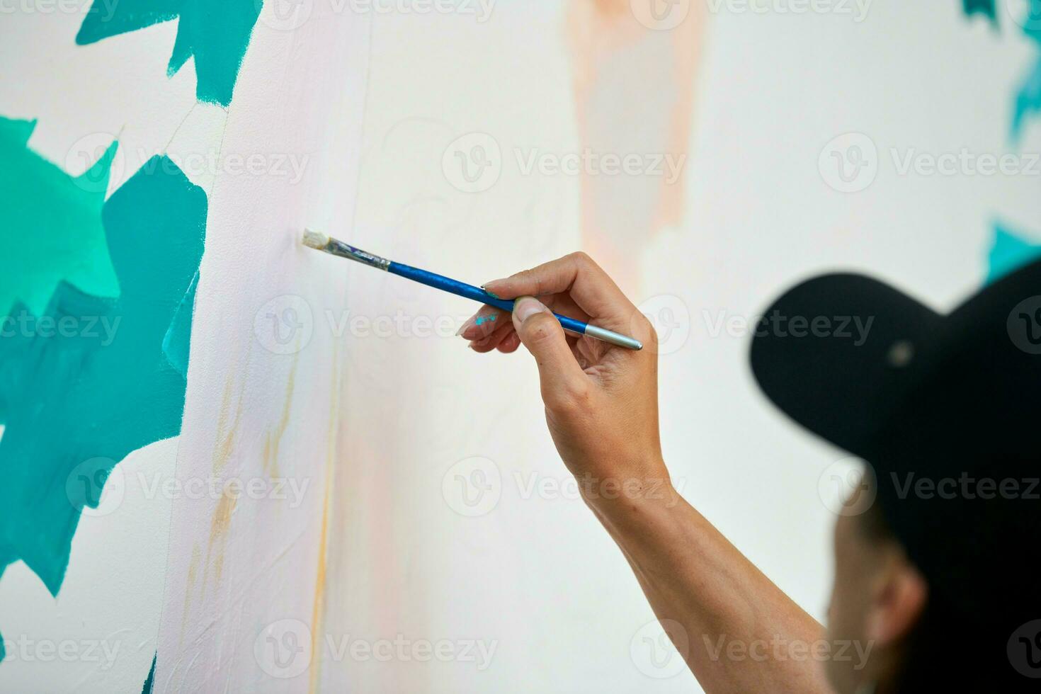 Girl artist draws with paint brush surreal woman portrait on white canvas at art painting photo
