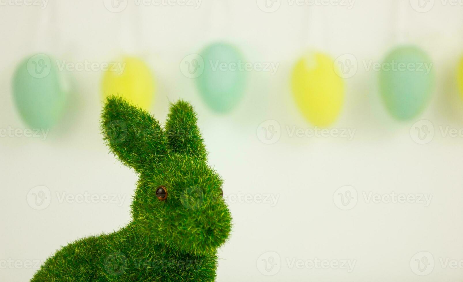 Green Easter bunny on a background of garlands of decorative eggs. photo