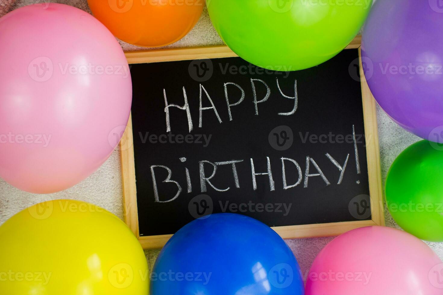 inscripción en un pizarra contento cumpleaños. multicolor globos alrededor el tablero. preparando para el cumpleaños. foto