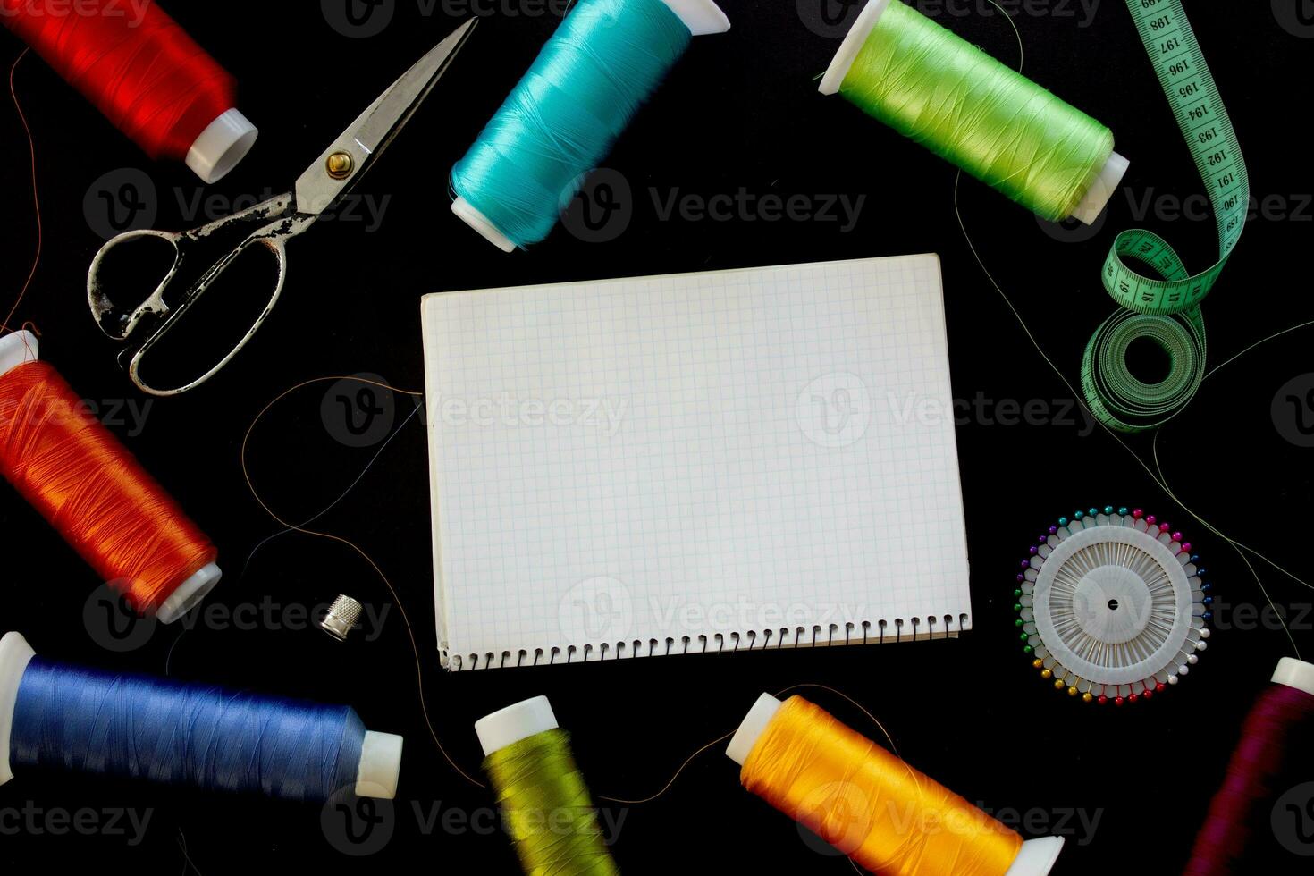 Sewing supplies and notepad for notes on a black background. Place for text. photo