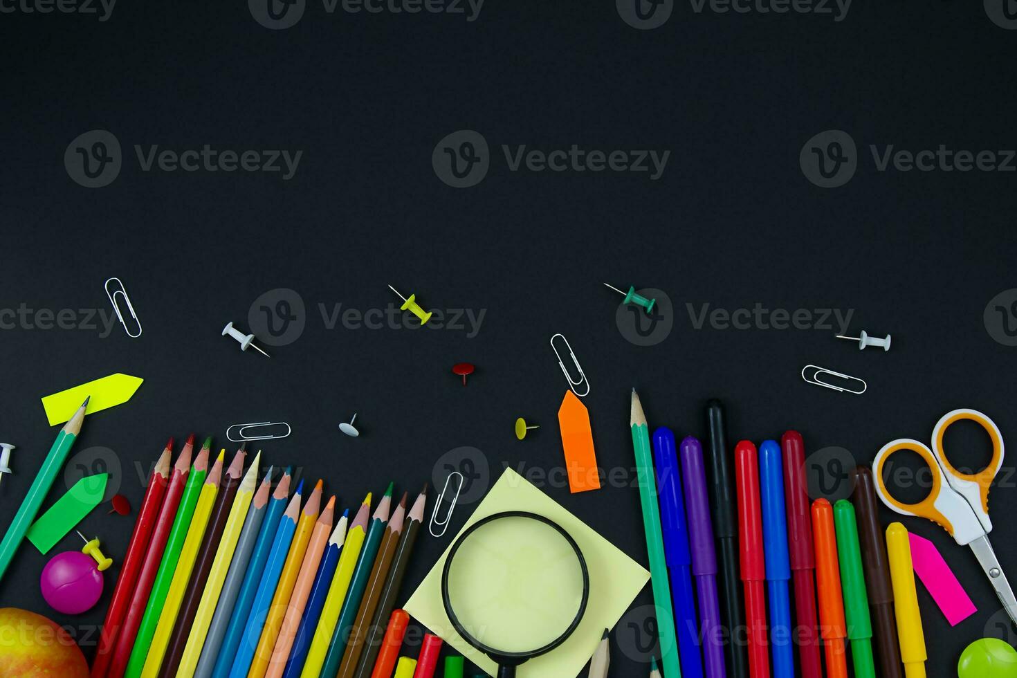 Multicolored stationery on a black background. Copy space. Back to school concept photo