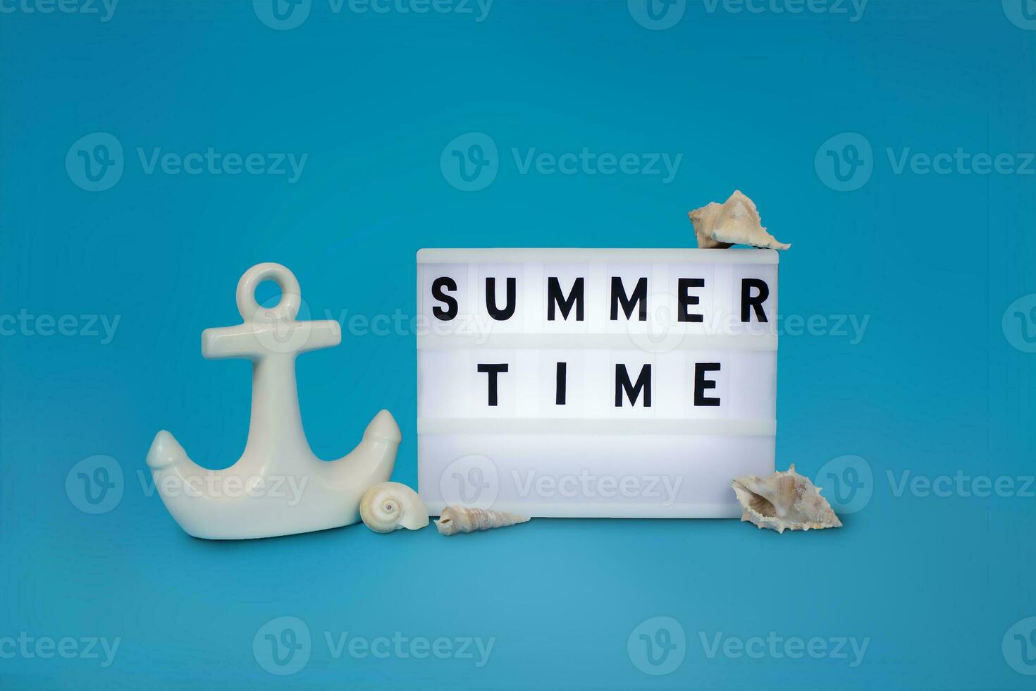 Inscription summer time, decorative anchor and seashells on a blue background. Summer background. Copy space. photo