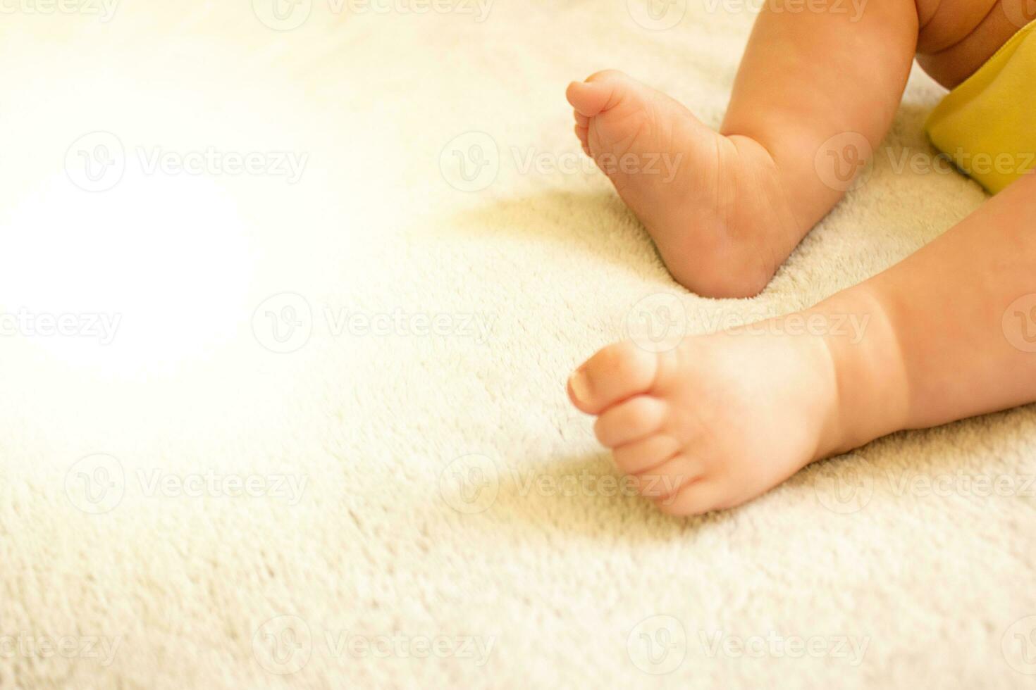 Baby's legs close up on a light blanket. Place for text. The concept of children's health, safety, love. photo