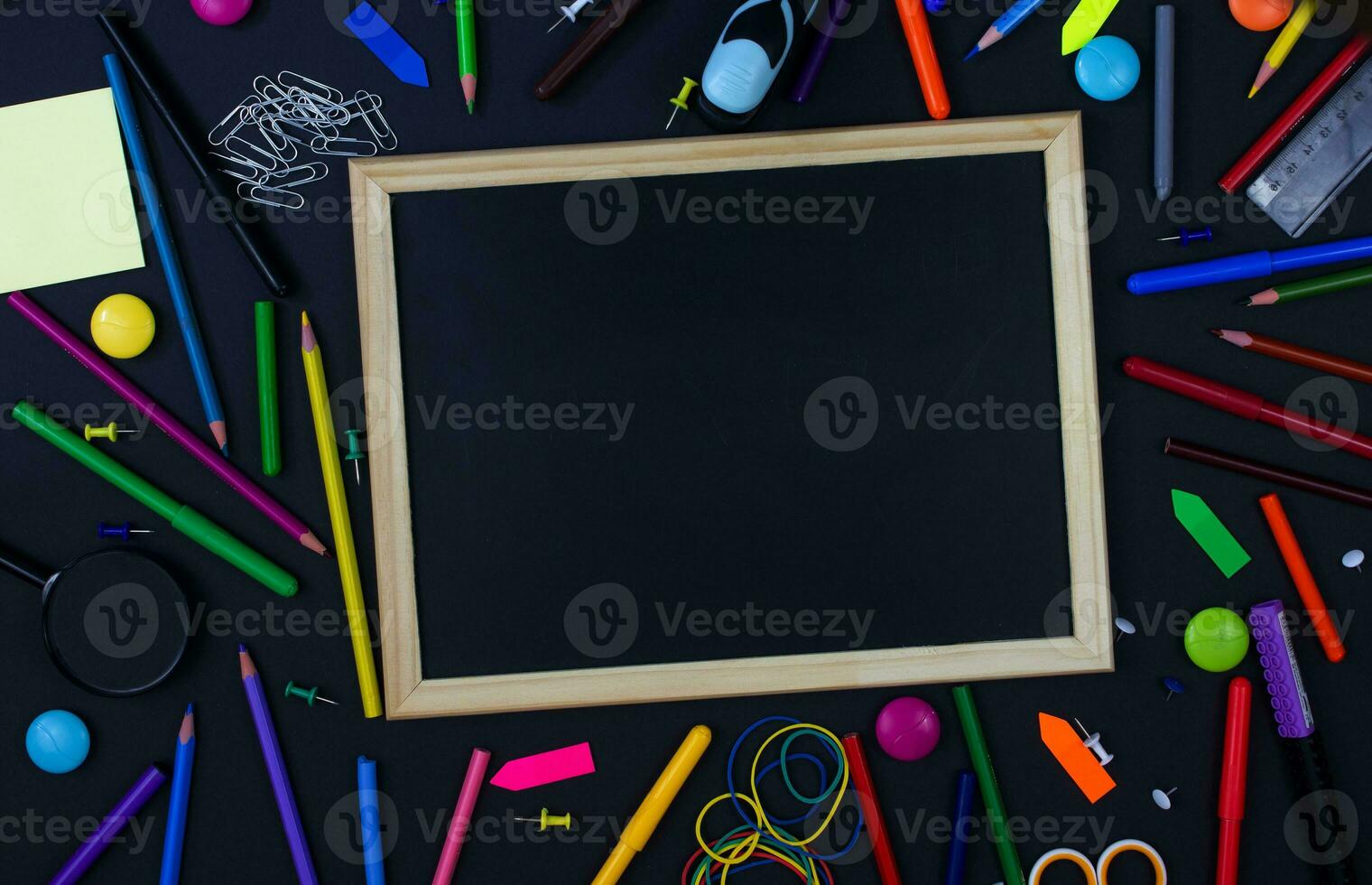 Stationery and writing board on a black background. Back to school concept. Place for text photo