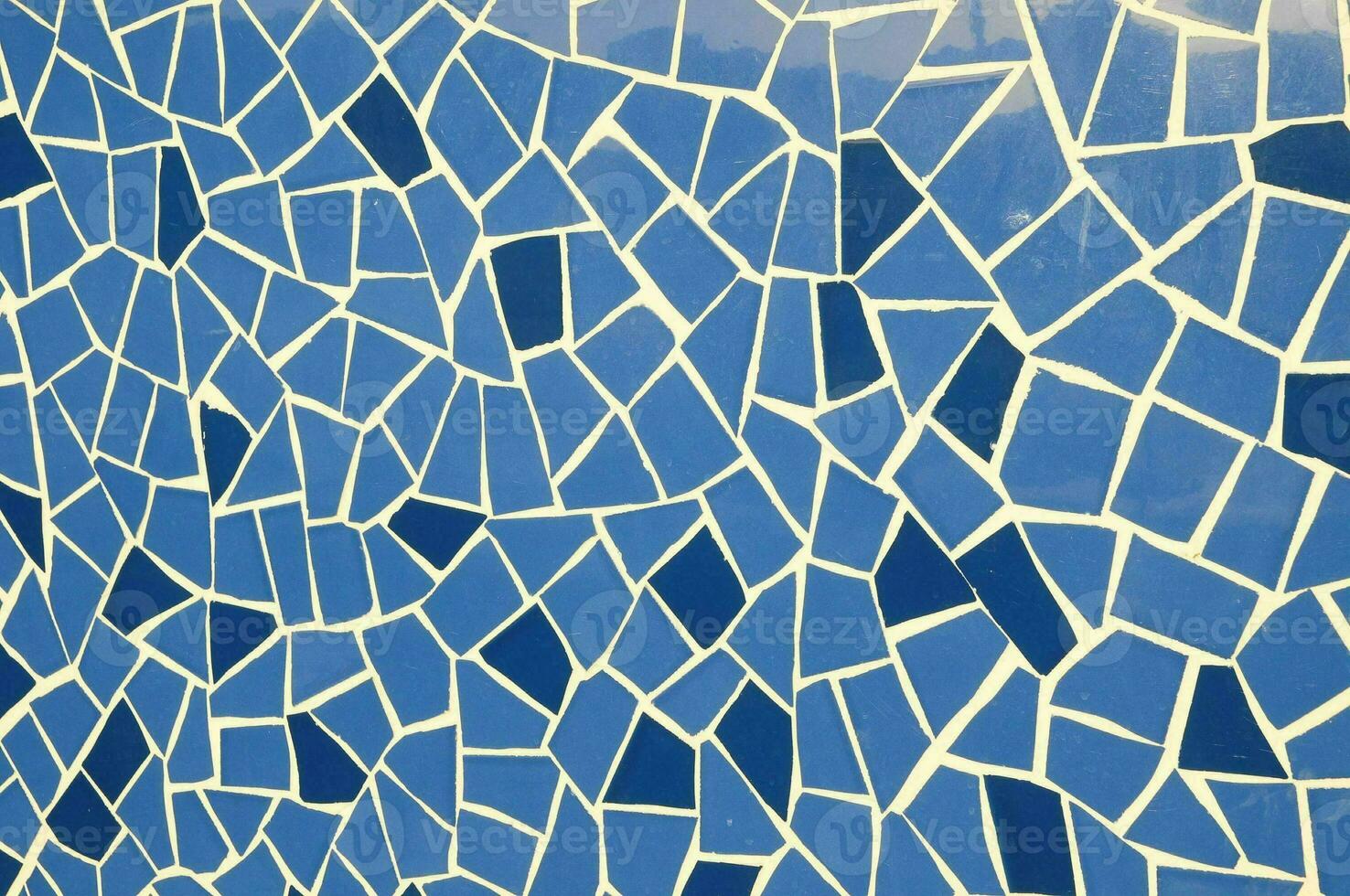 a blue mosaic wall with white and blue tiles photo