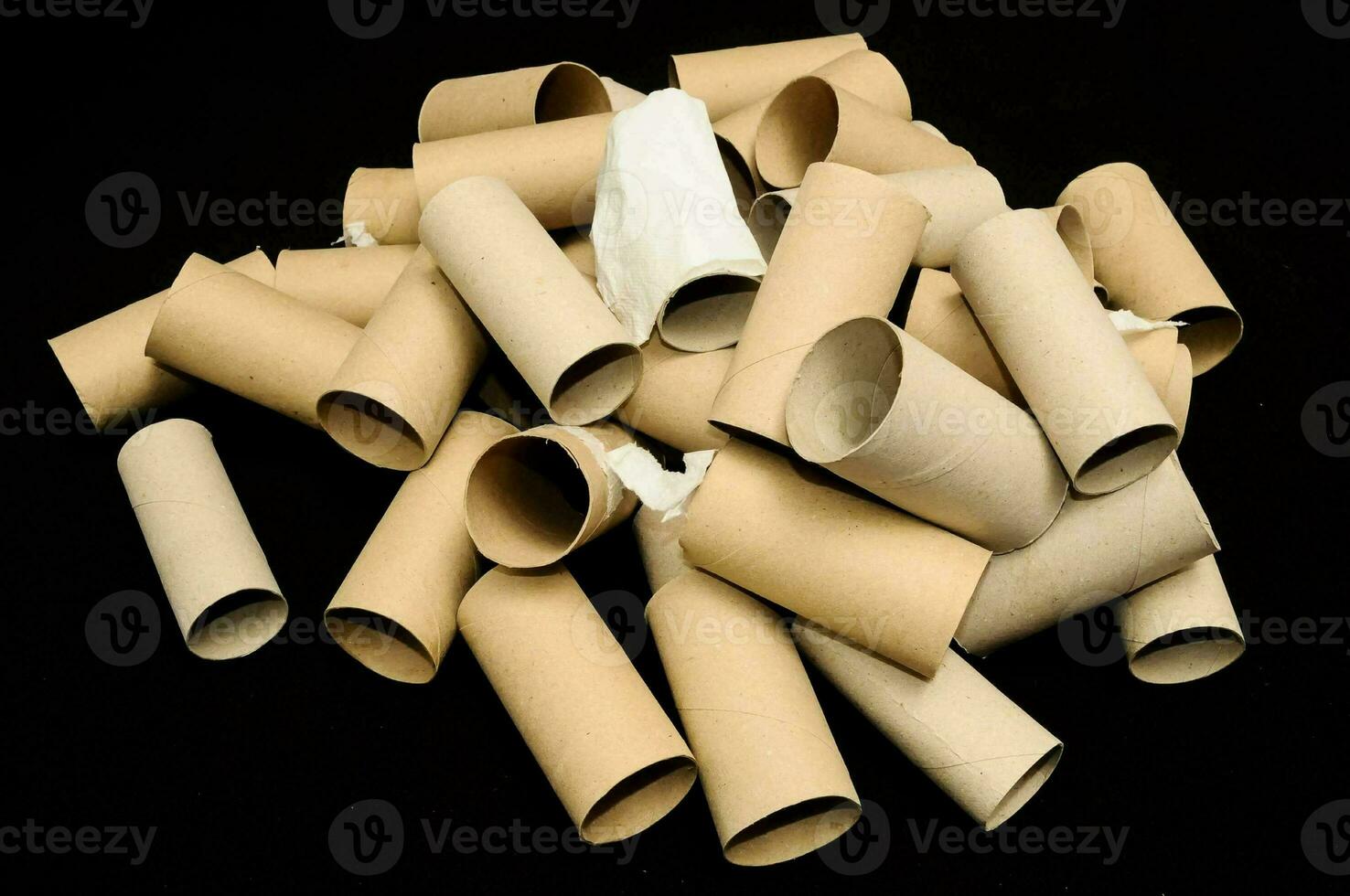 a pile of toilet paper rolls on a black surface photo