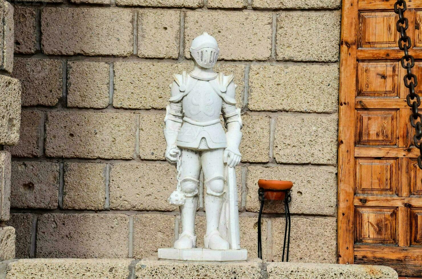 a statue of a knight stands outside of a building photo