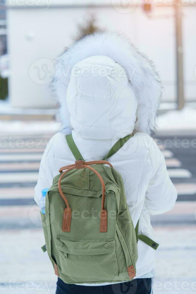 happy Traveler with Sweater and backpack walking on snow covered road in frosty weather, woman tourist sightseeing in Sapporo city, Hokkaido, Japan Winter Travel and Vacation concept photo