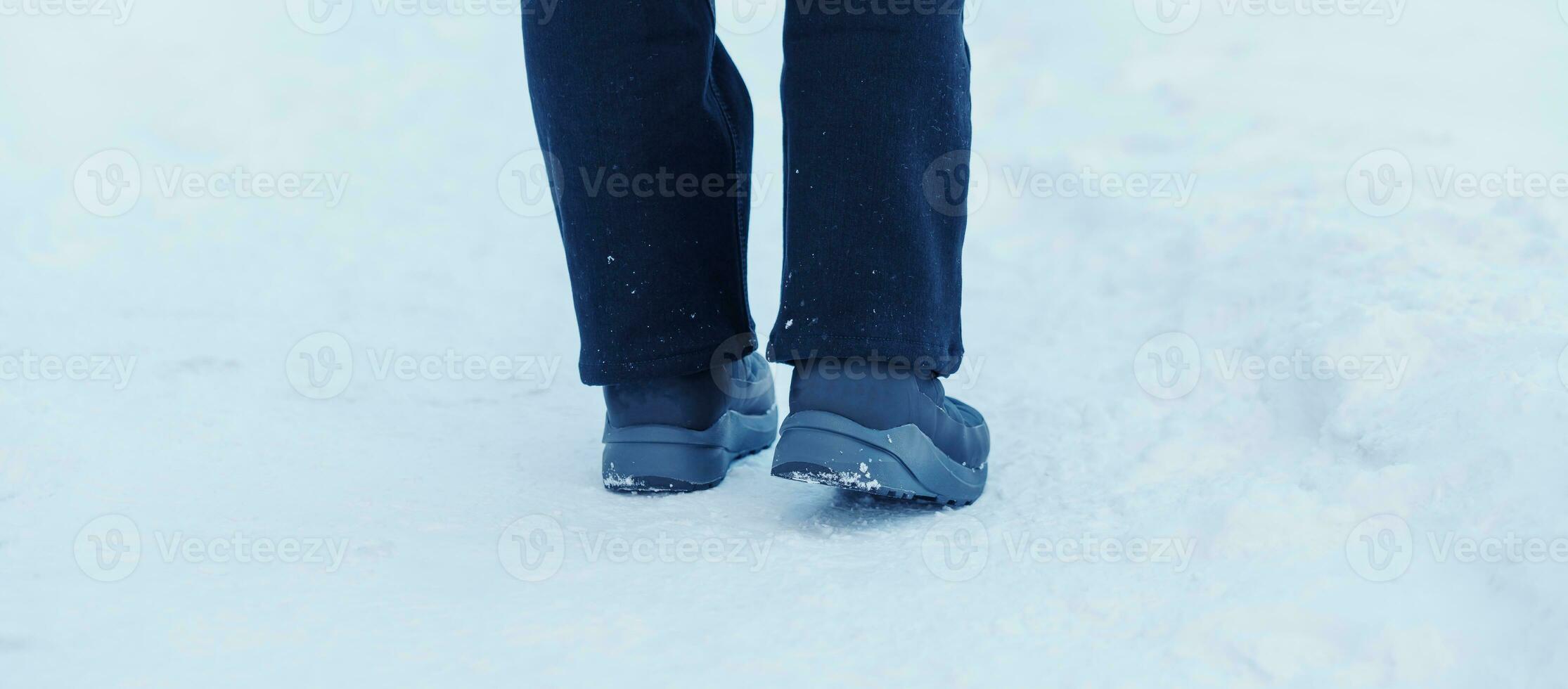 traveler walking on the snow,  closeup waterproof boots or shoes during hiking on snowy forest. Winter season photo