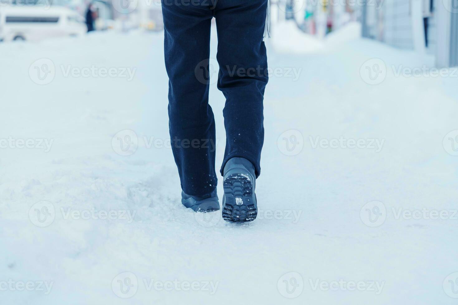 traveler walking on the snow,  closeup waterproof boots or shoes during hiking on snowy forest. Winter season photo