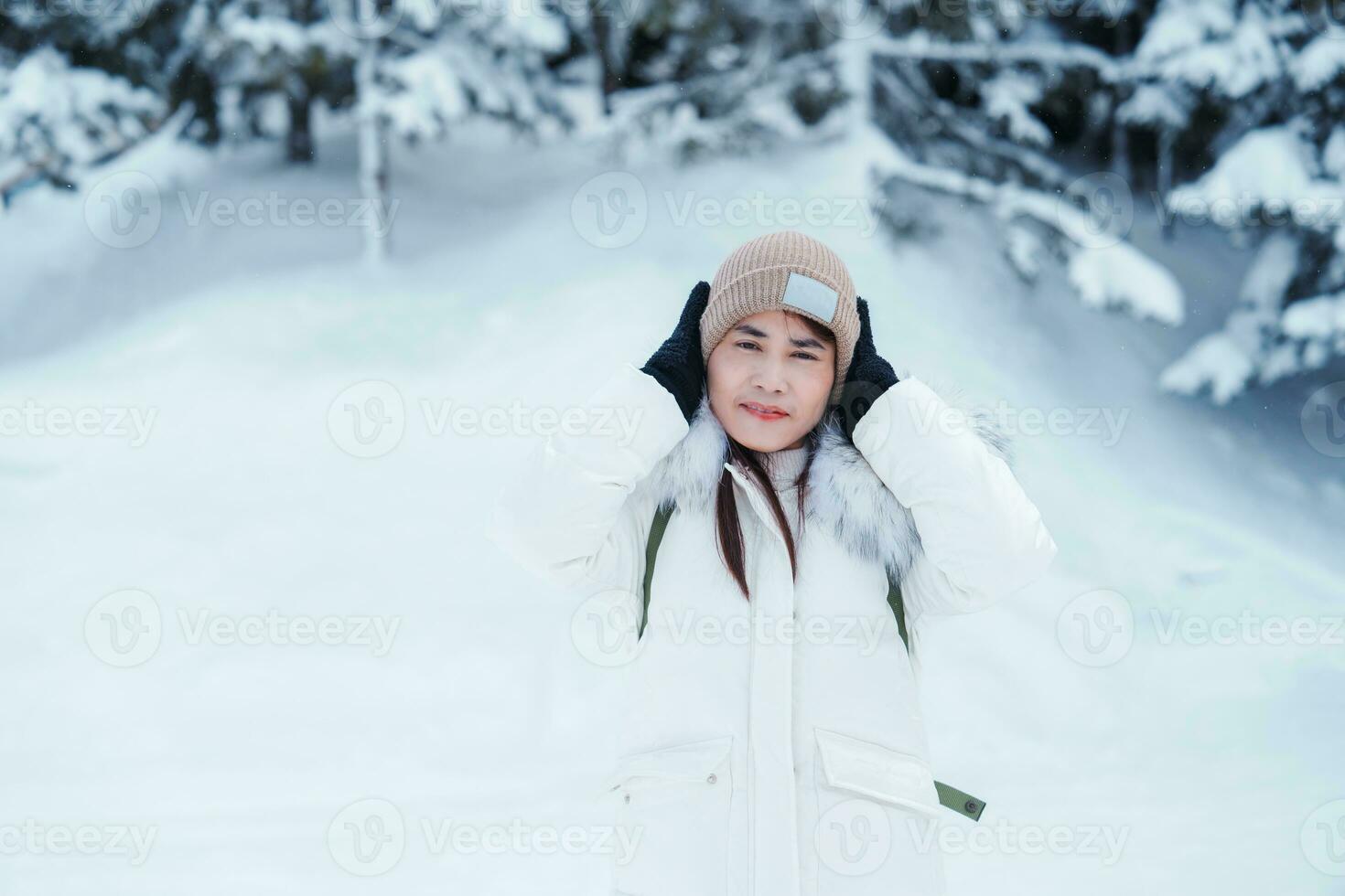 happy Traveler with Sweater and backpack walking on snow covered forest in frosty weather. Winter Travel, Adventure, Exploring and Vacation concept photo