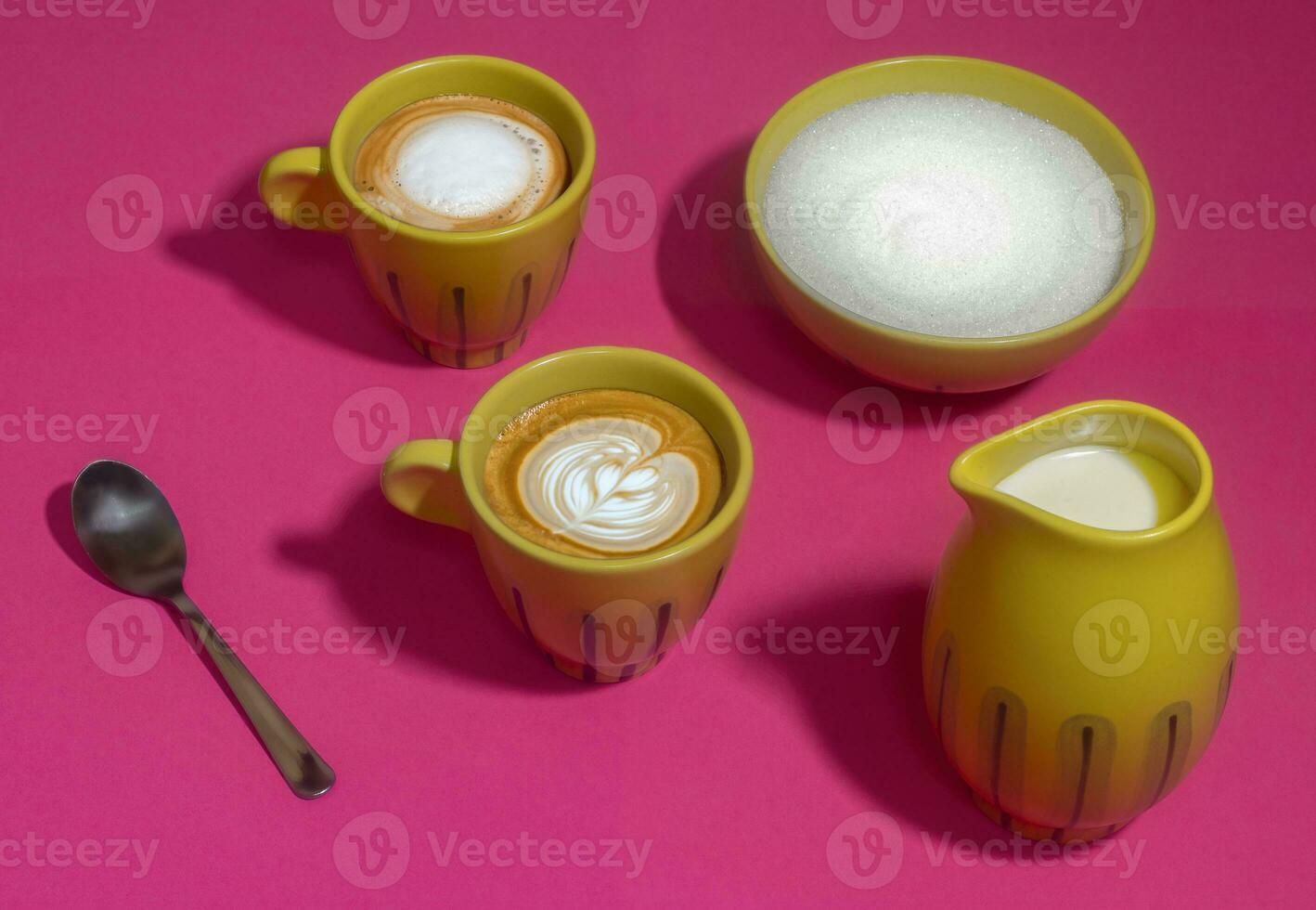 Latte mugs on hot pink background, yellow and white photo