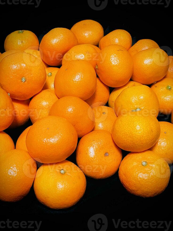 piles of sparkling and appetizing fresh citrus fruit on a black background photo