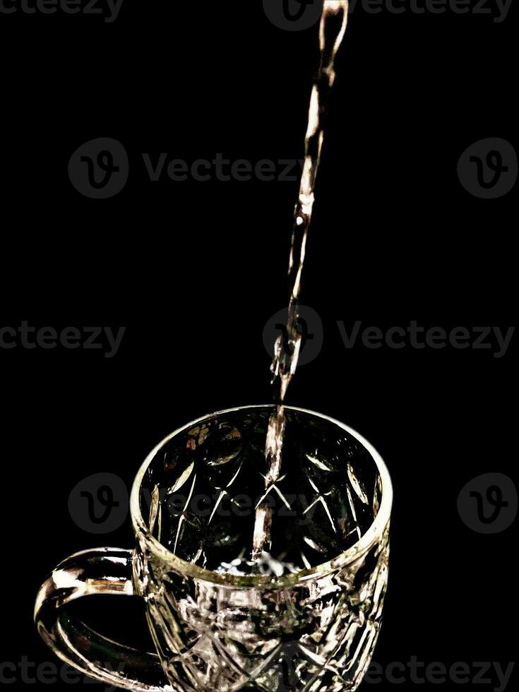 Aesthetic photo of pouring water into a glass with black background
