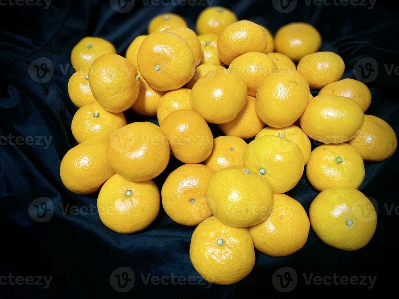 piles of sparkling and appetizing fresh citrus fruit on a black background photo
