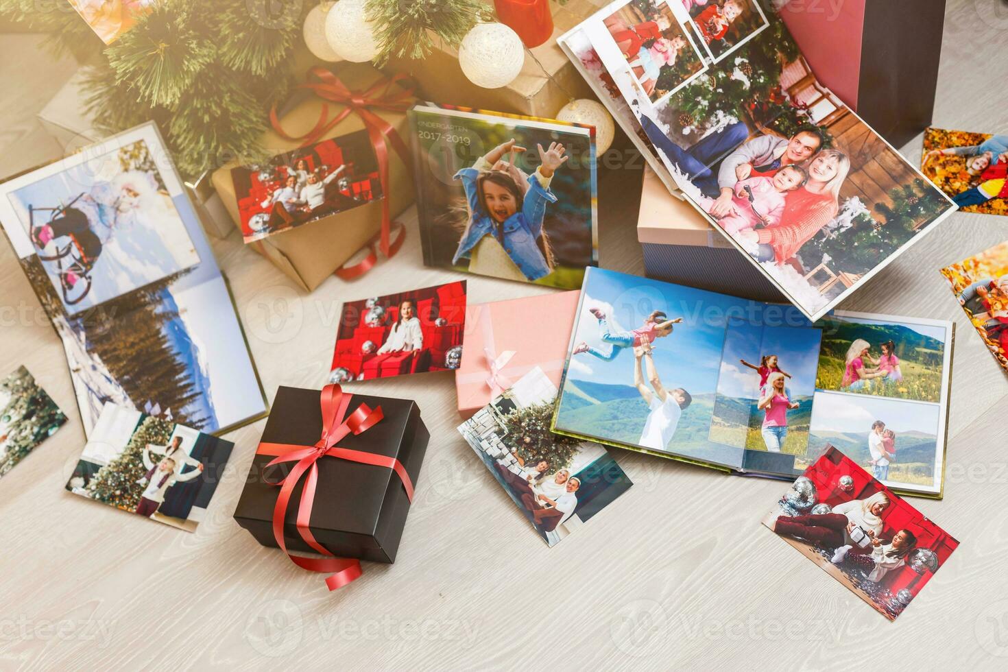 New Year celebrating. Photobook with photos of summer travel under the Christmas tree