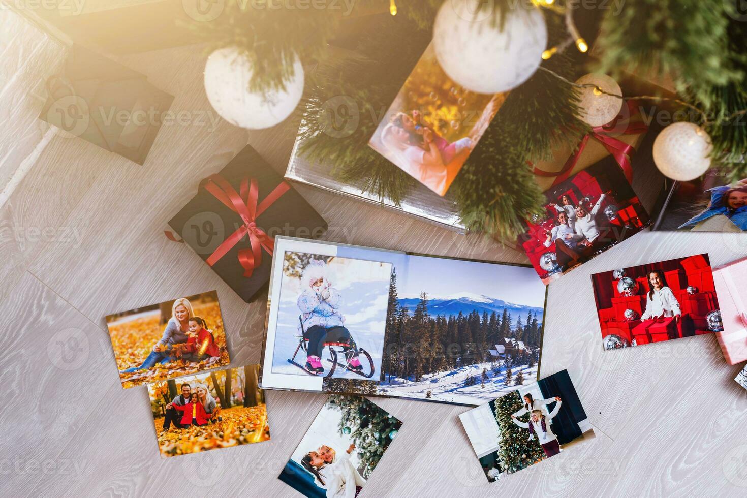 New Year celebrating. Photobook with photos of summer travel under the Christmas tree