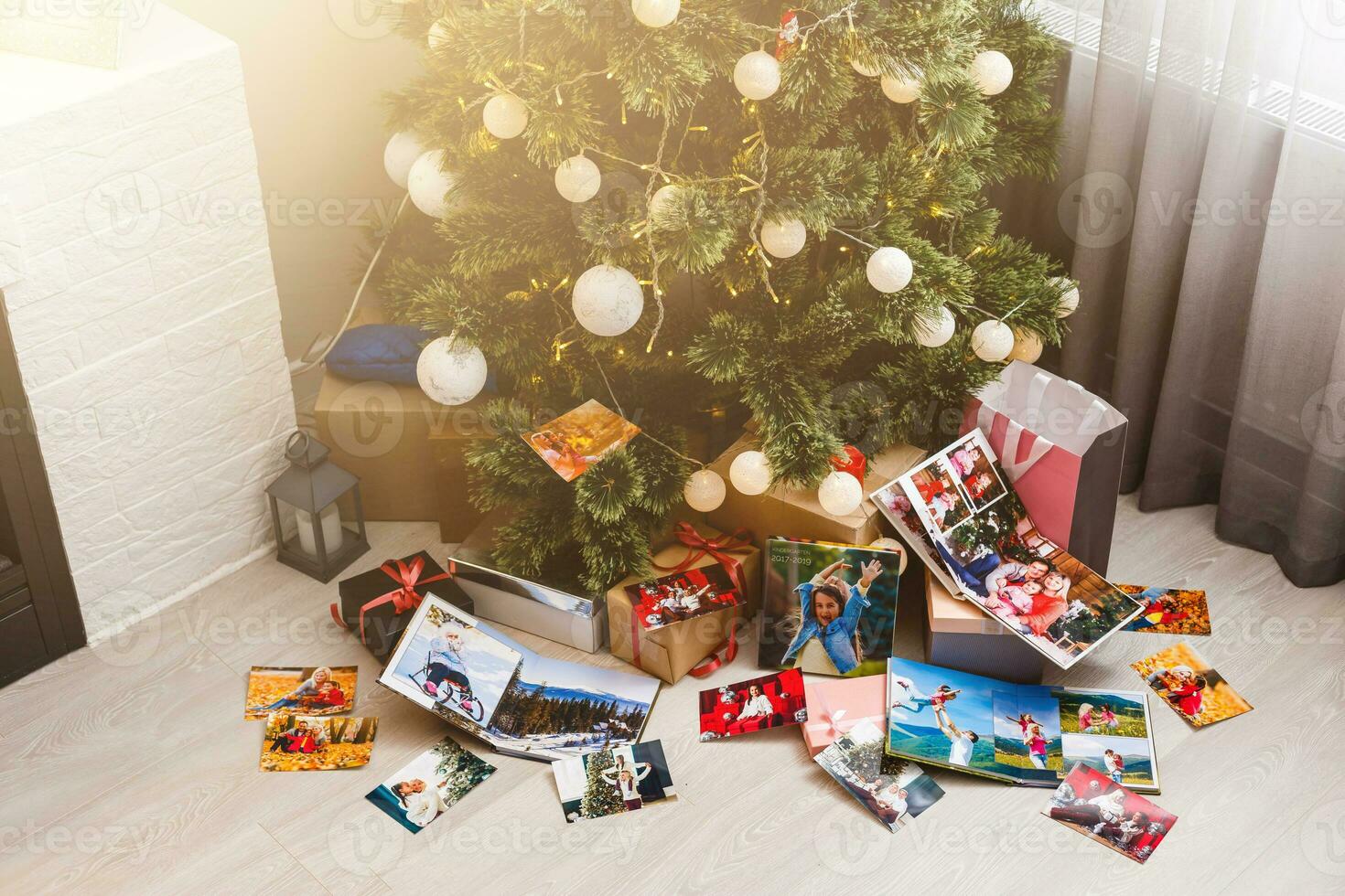 New Year celebrating. Photobook with photos of summer travel under the Christmas tree