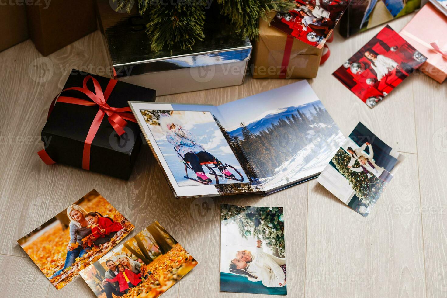 New Year celebrating. Photobook with photos of summer travel under the Christmas tree