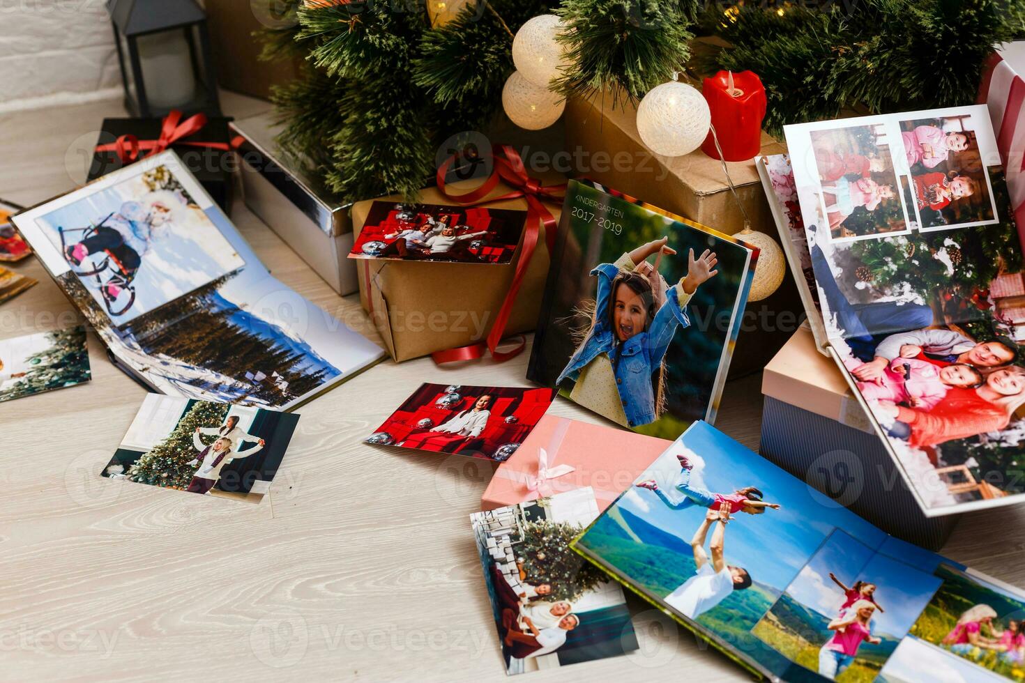 New Year celebrating. Photobook with photos of summer travel under the Christmas tree