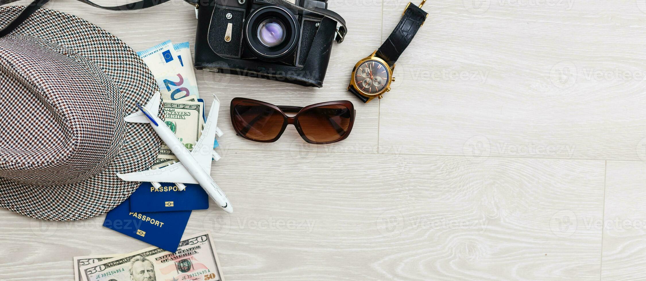 Travel preparation. A lot of objects are scattered on gray background - a camera, tickets, documents, a toy plane. Family holidays, holidays near the sea, holidays. photo