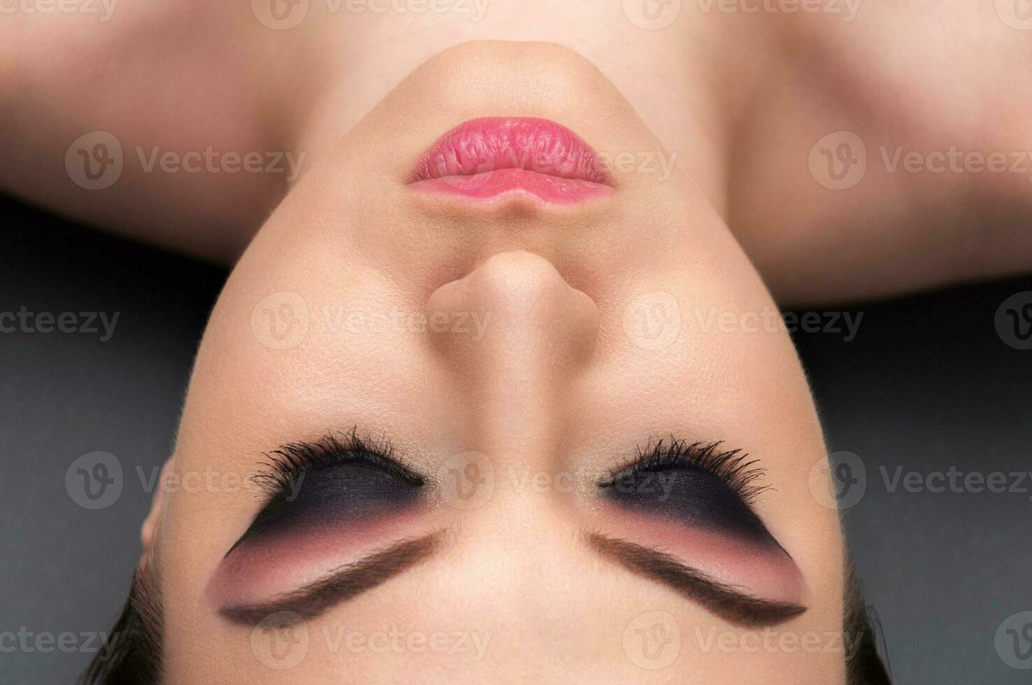 Beautiful young model with professional make up, close up shot on the grey background photo