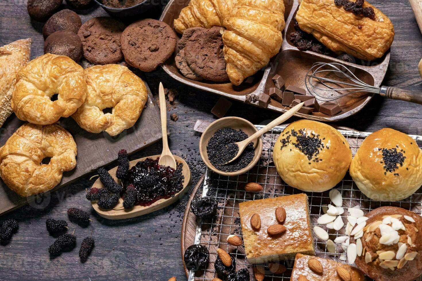 Table top view of organic rustic style bakery with whole grain bun, bread and cookies with various berry and nut for homemade healthy pastry and traditional baking bread concept photo