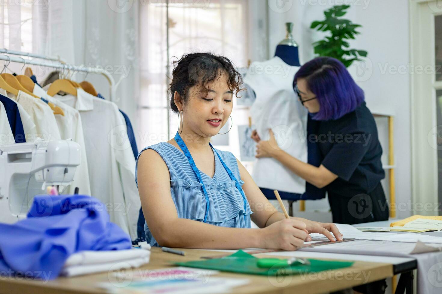 Fashionable freelance dressmaker is designing on new dress by drawing illustrator while working in artistic workshop studio for fashion design and clothing business industry photo
