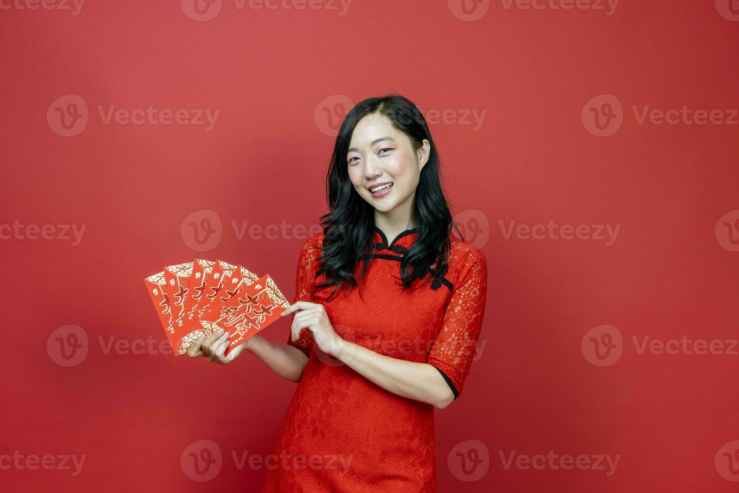 Asian woman holding red money fortune envelope blessing Chinese word which means, May you have great luck and great profit, isolated on red background for Chinese New Year celebration photo