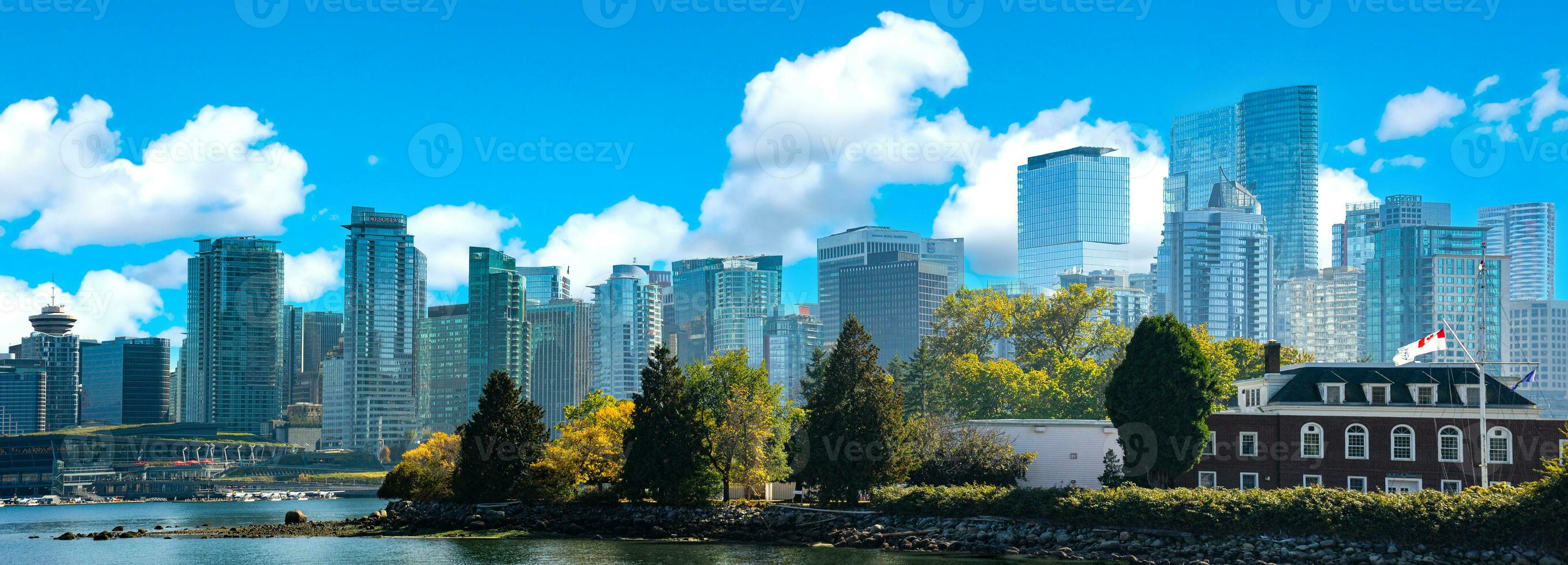 A panoramic photograph taken from Stanley Park in British Columbia, Canada, featuring the city and the Vancouver skyline. photo