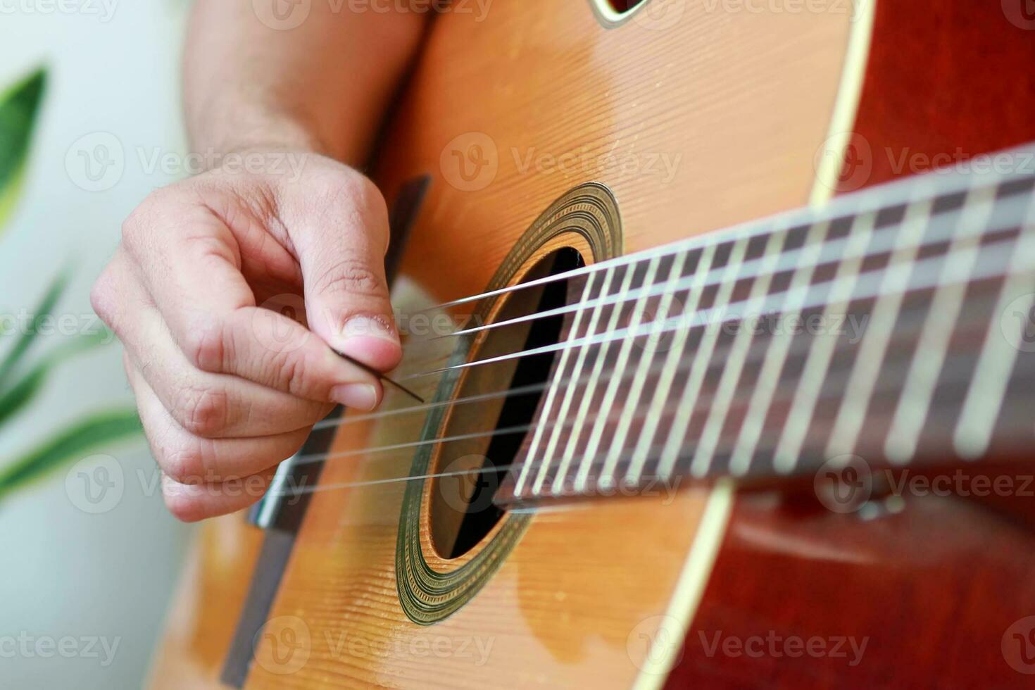 Using a pick for an acoustic guitar. photo