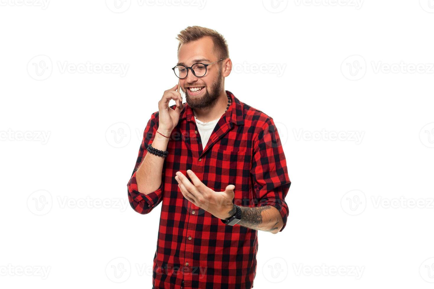 Portrait of a casual young man speaking on the phone and smiling while looking away, somewhere up. Studio shot on white background photo