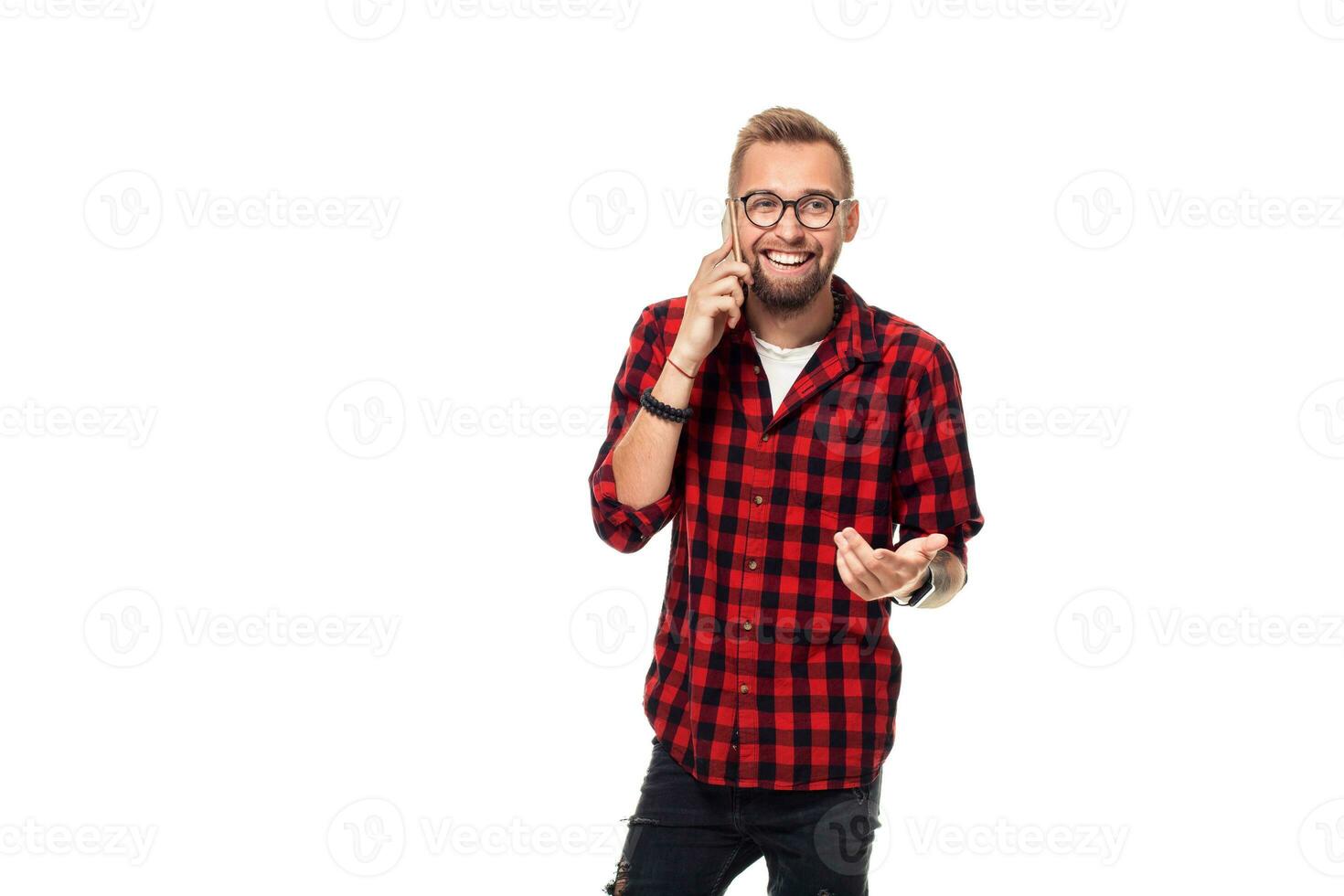 Portrait of a casual young man speaking on the phone and smiling while looking away, somewhere up. Studio shot on white background photo