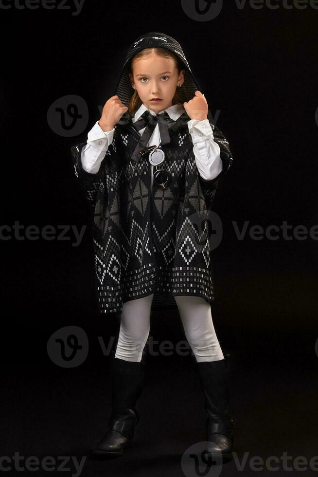 Little girl in a hood and a dark poncho photo