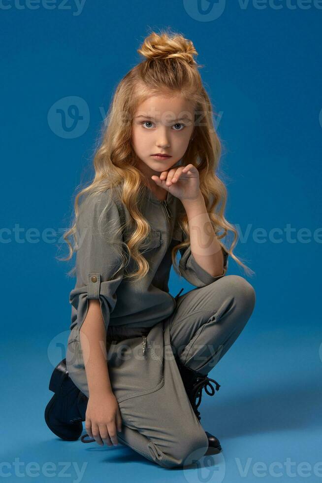 Little girl with a long curly hair in a fashionable clothes photo