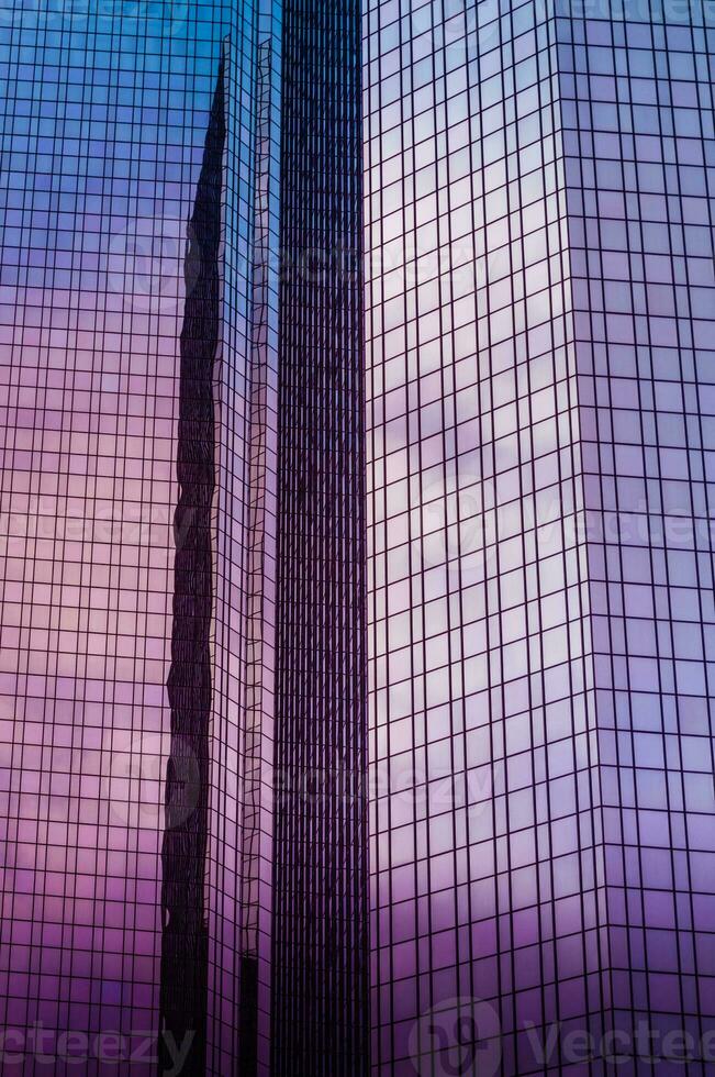 Close up shot of office windows in the skyscraper mirroring the cloudy sky photo