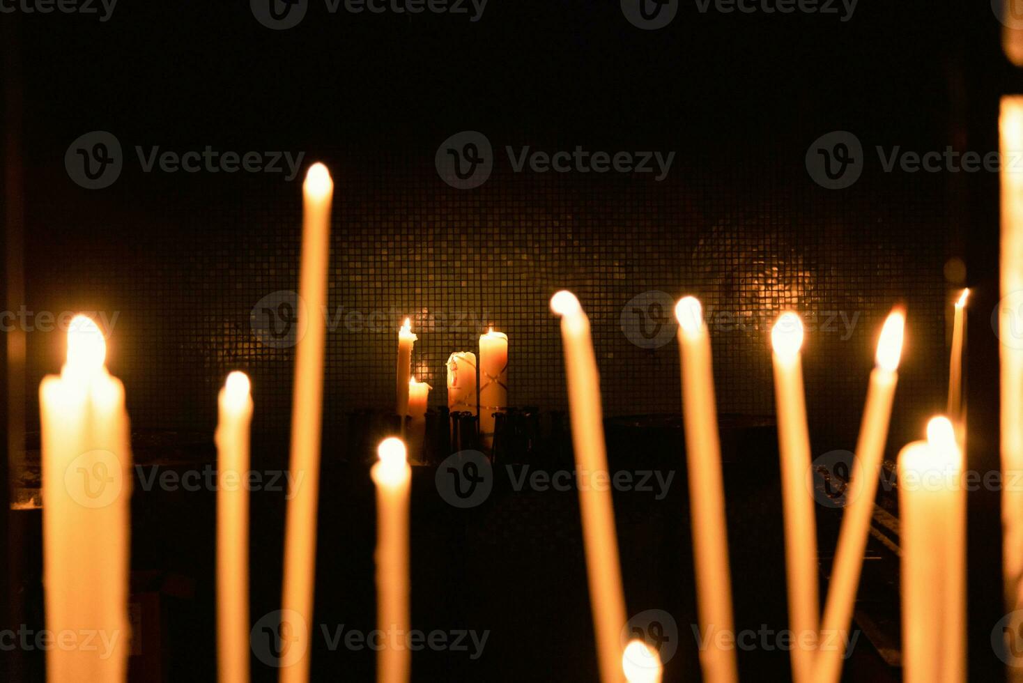 Candles in a dark room being waxed glass photo