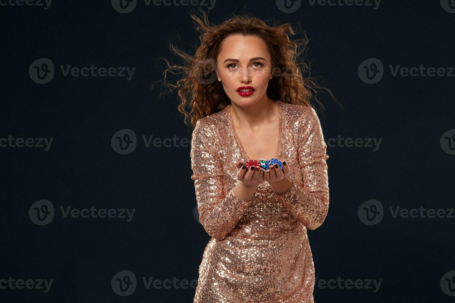 Casino concept. Portrait of young pretty caucasian woman, playing in casino. Roulette, poker chips, cards, wheel, black background photo