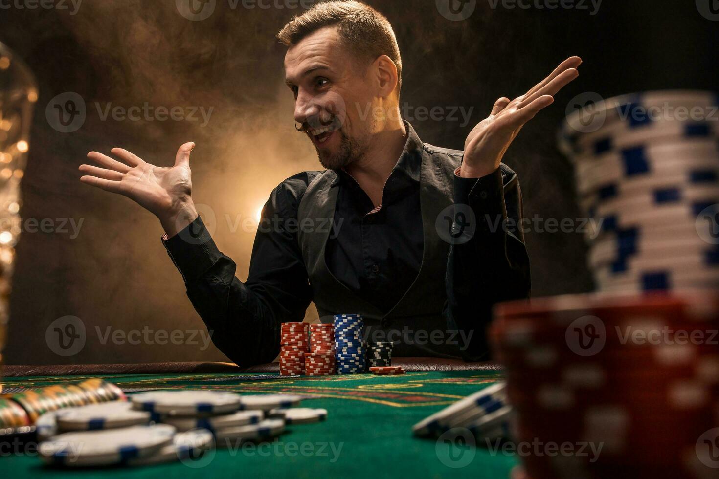 hombre es jugando póker. un hombre victorioso todas el papas fritas en el mesa con grueso cigarrillo fumar. el concepto de victoria foto