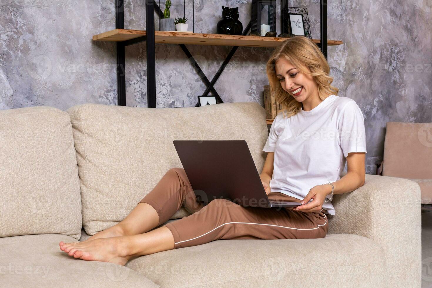 Young beautiful woman using laptop computer smiling happy watching and browsing or doing online internet shopping at home. photo