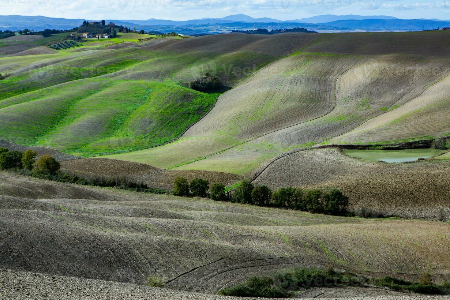 Harvested Fields and meadows landscape in Tuscany, Italy. Wavy country scenery at autumn sunset. Arable land ready for the agricultural season. photo