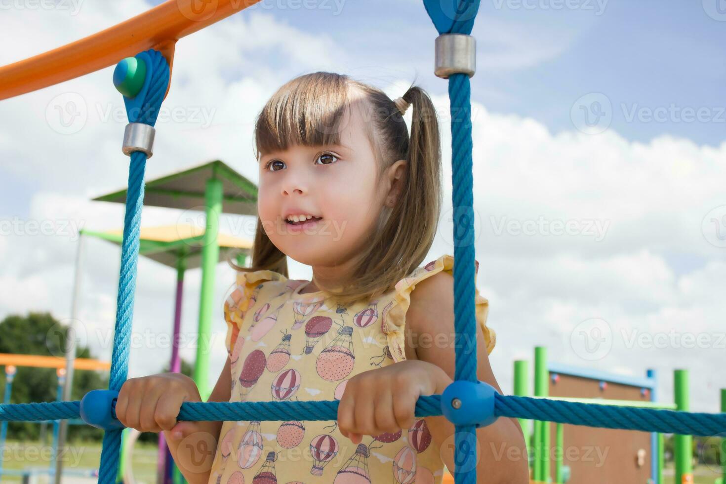 pequeño contento niña jugando en el patio de recreo foto