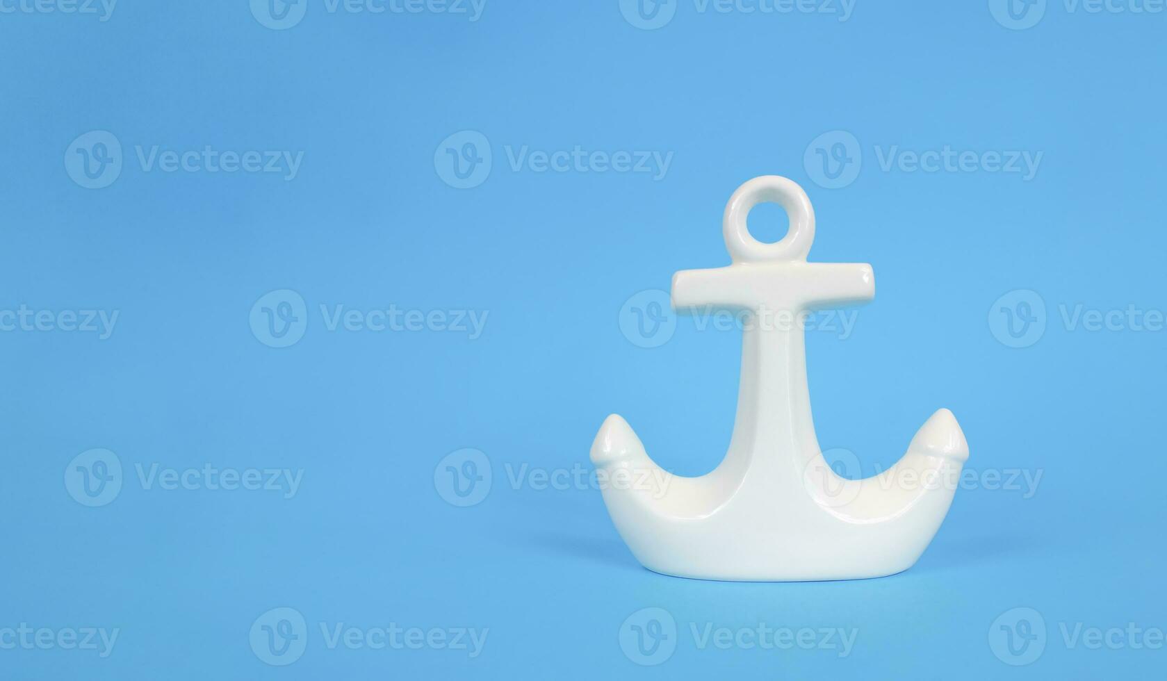 White anchor on a blue background. Copy space. Vacation concept. photo